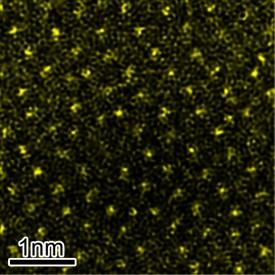 図1: イットリウムドープした酸化アルミニウム結晶粒界面の走査型透過電子顕微鏡像。イットリウム原子（黄色い点）の分布と秩序構造が見て取れる。イットリウム原子同士は0.3～0.5 nm離れている。