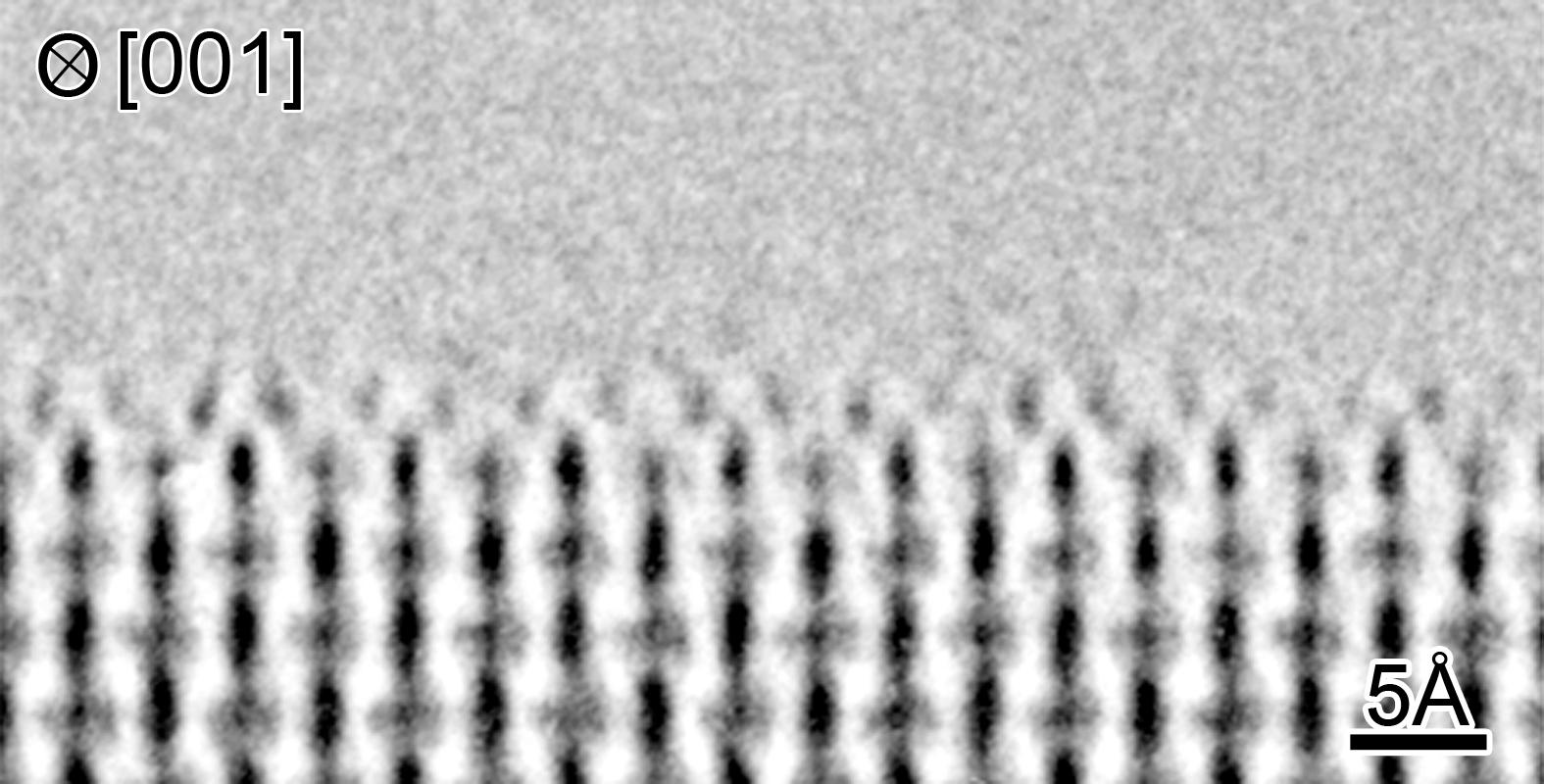 図1: 超高圧高分解能透過型電子顕微鏡を使い、[001]方向から観察した酸化チタンTiO2 (110)の表面構造。表面において再構成原子が観察できる。